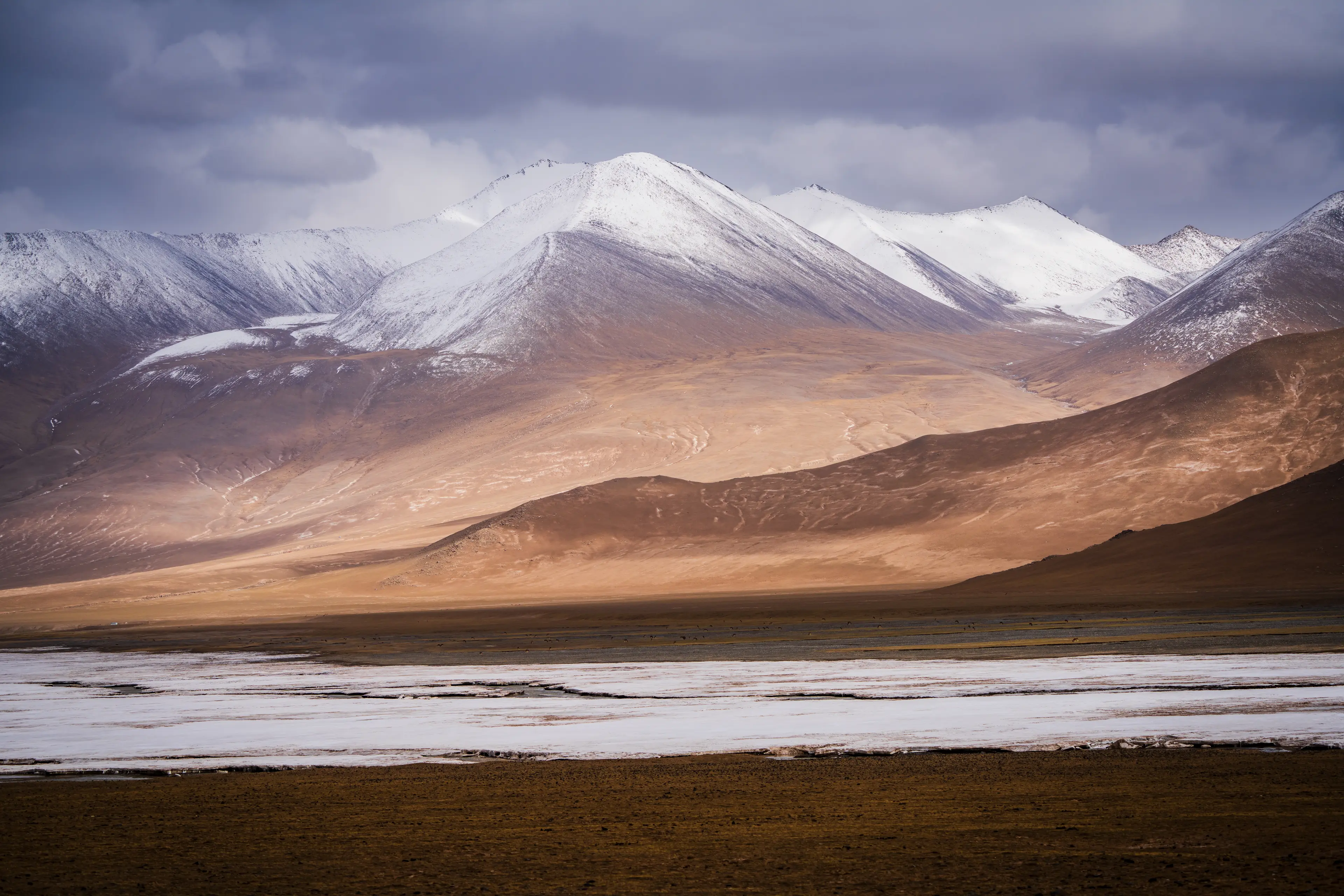 Snow-capped mountains and open plateau flats in Hoh Xil